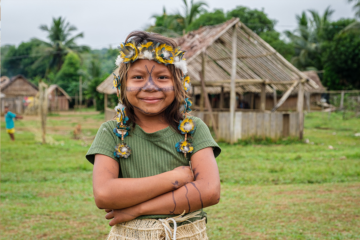 Kind der Munduruku, mit typischen Kopfschmuck aus Arafedern und traditioneller Bemalung